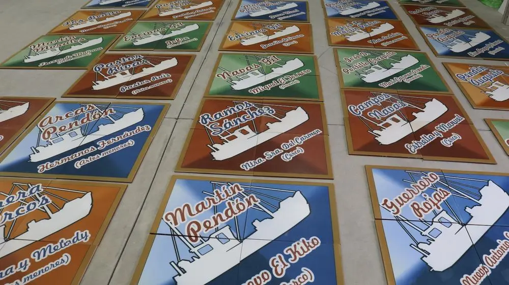 Serie de baldosas con barcos pesqueros y nombres de familias, en el taller