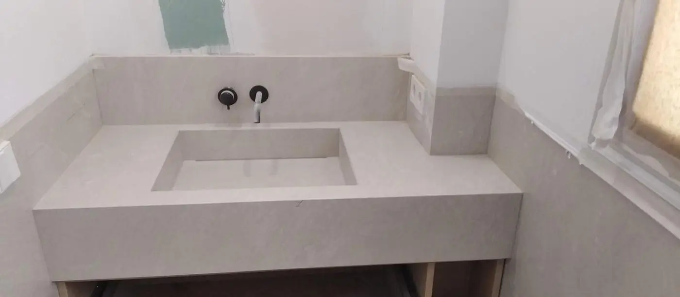 Lavabo integrado con frente y copete de porcelánico beige, recién colocado