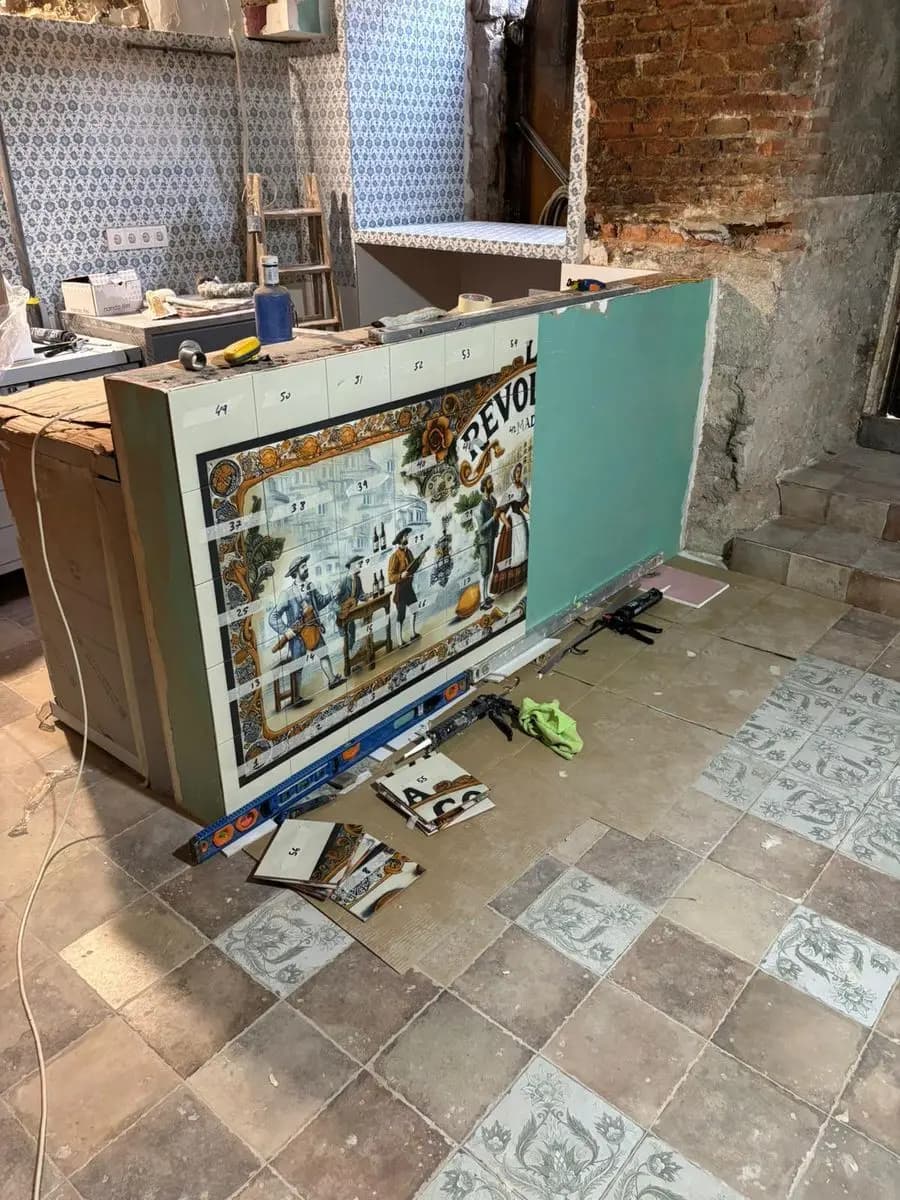 Mural costumbrista en azulejo revistiendo la barra de un local en obra