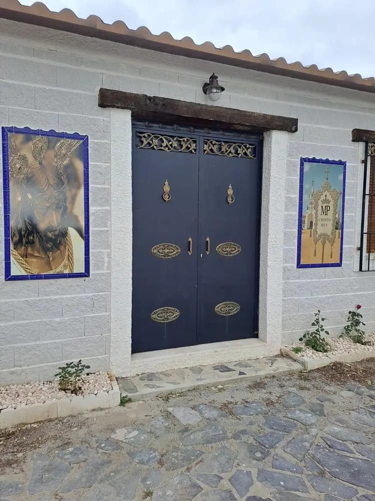 Dos murales religiosos a los lados de la puerta de una casa de campo