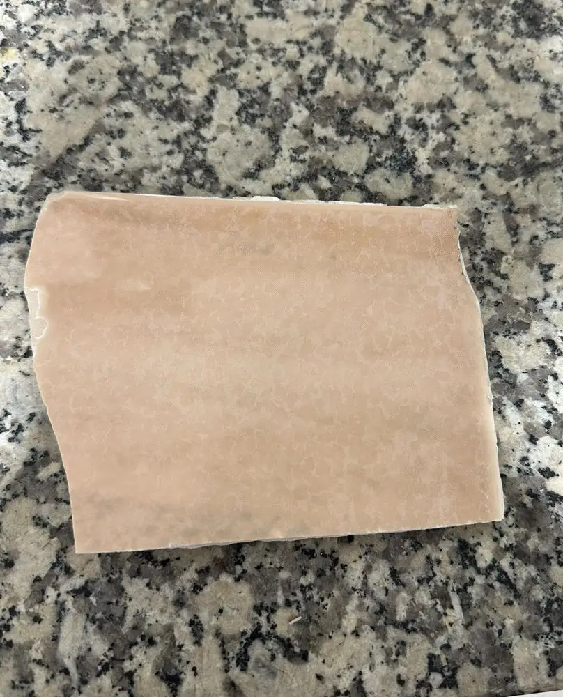 Trozo de un azulejo rosado descatalogado, tal como llega al taller