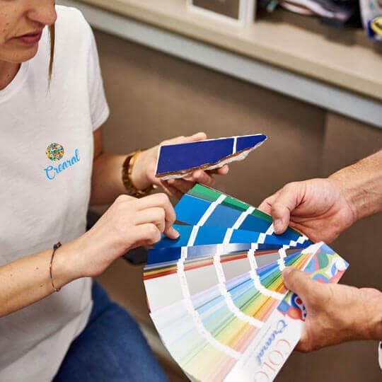 Carta de colores de esmaltes junto a un trozo de azulejo azul