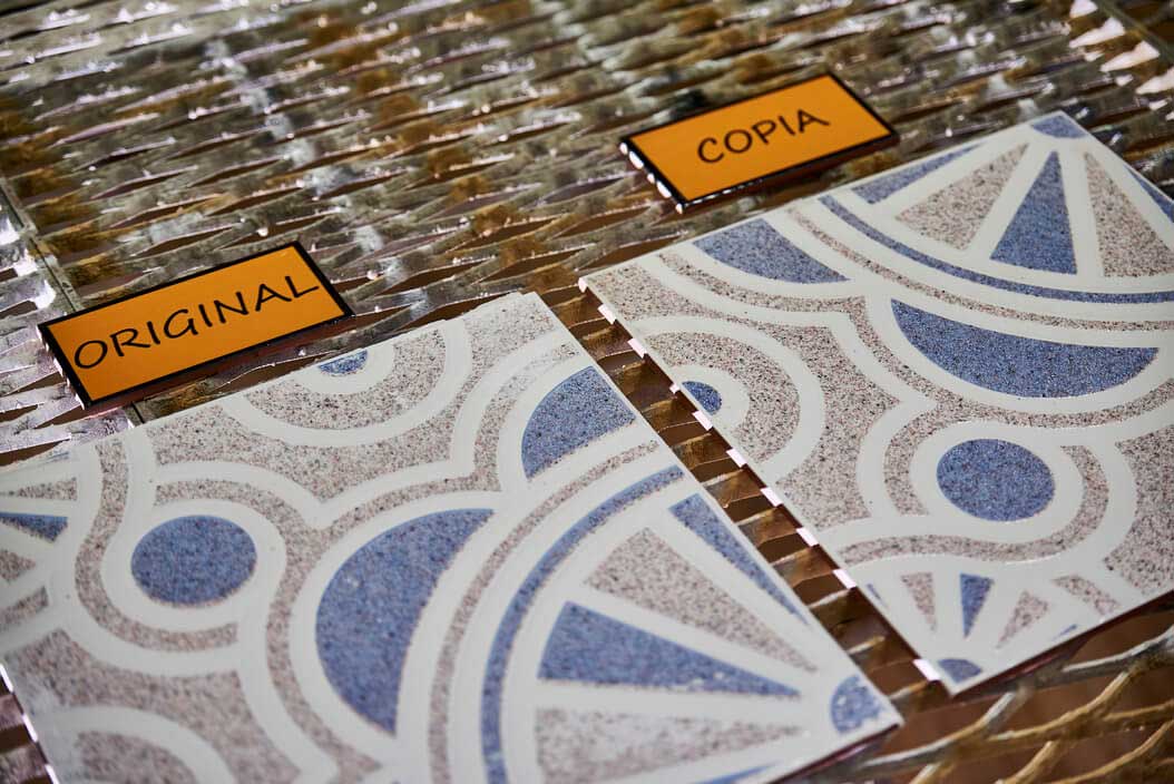 Azulejo con dibujo geométrico azul: pieza original y copia
