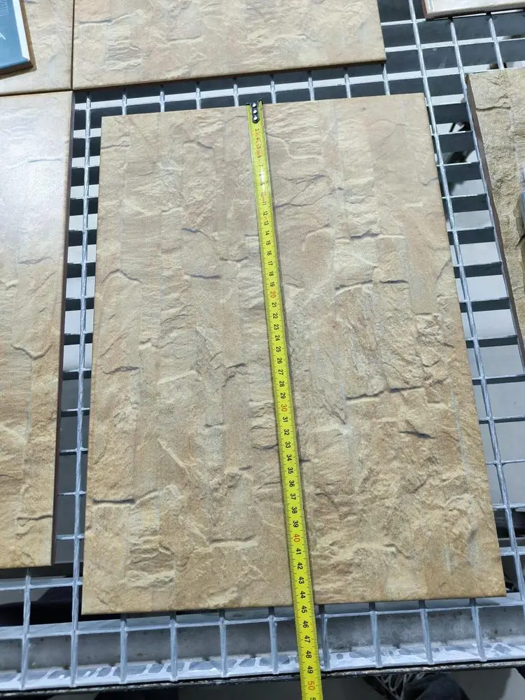 Pieza alargada efecto piedra rústica medida con cinta métrica sobre la rejilla del taller