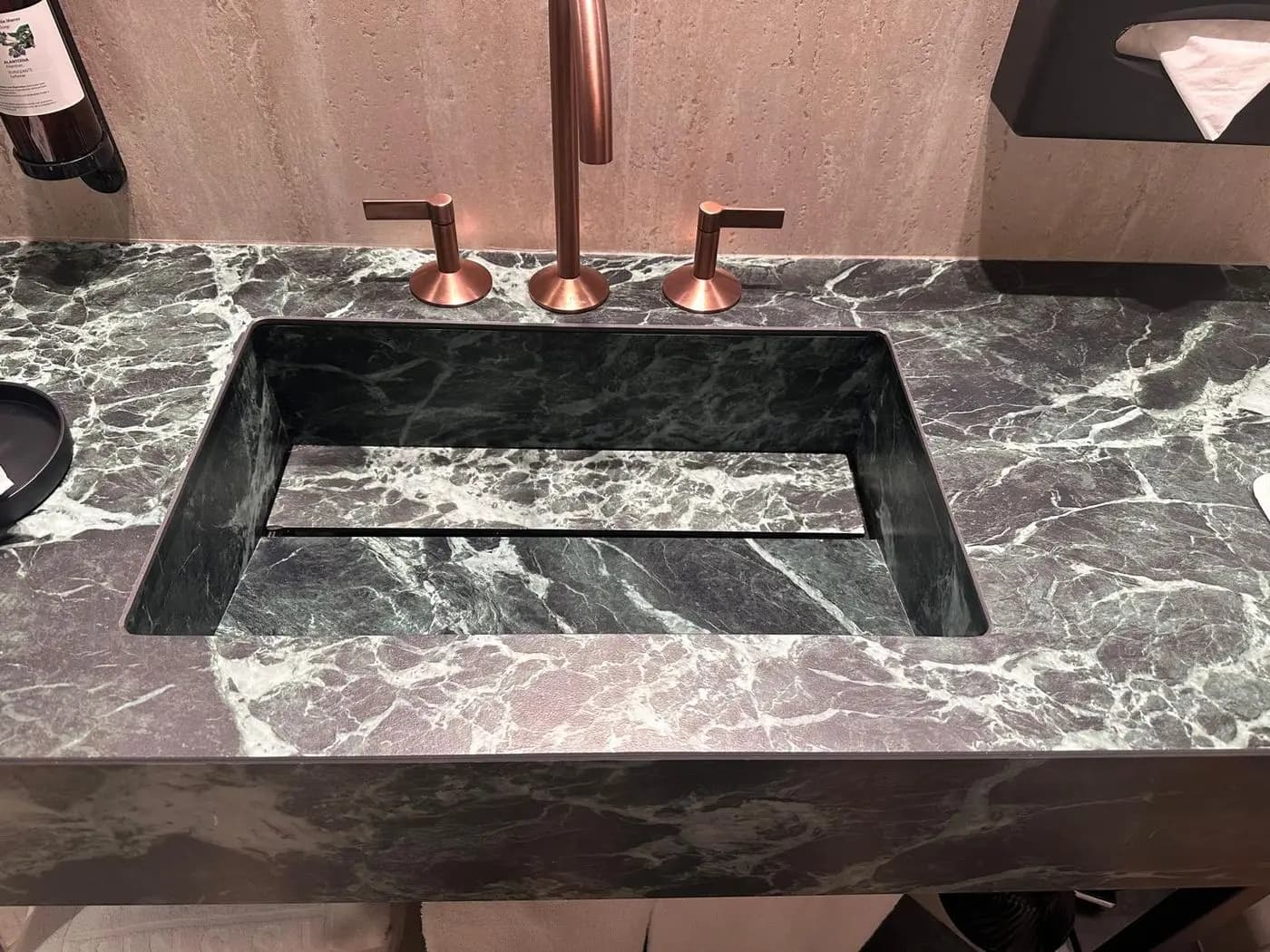 Lavabo integrado de porcelánico efecto mármol verde con grifería de cobre