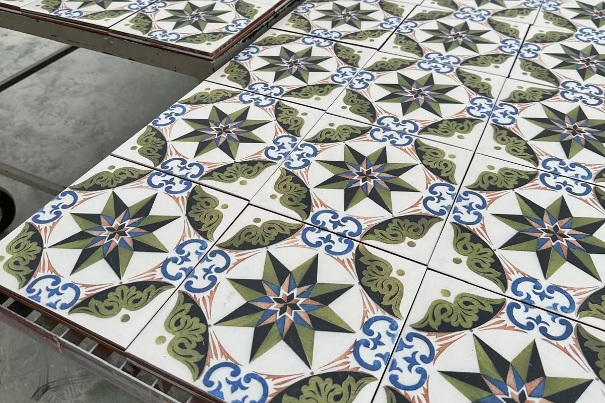 Réplicas de azulejo hidráulico con estrella verde y azul en el taller