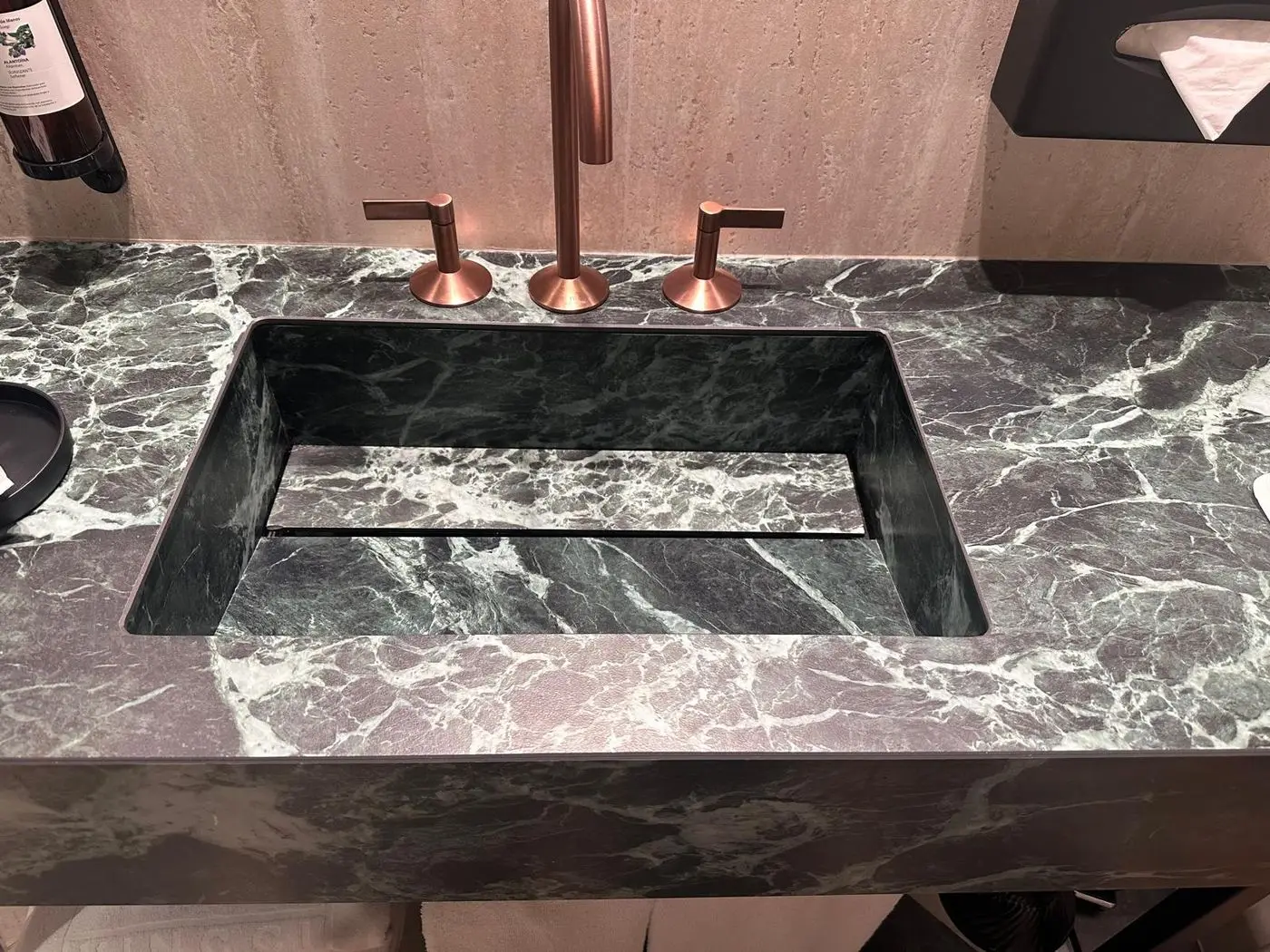 Lavabo integrado de porcelánico efecto mármol verde con grifería de cobre