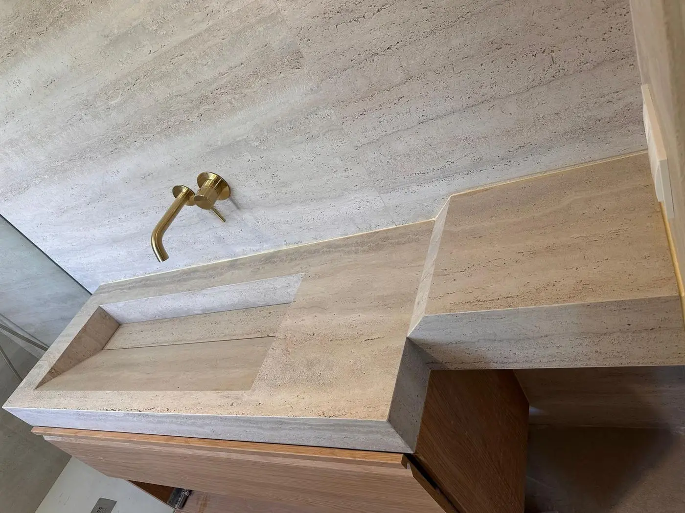 Vista desde arriba de la encimera de travertino porcelánico: la veta sigue por el canto a inglete
